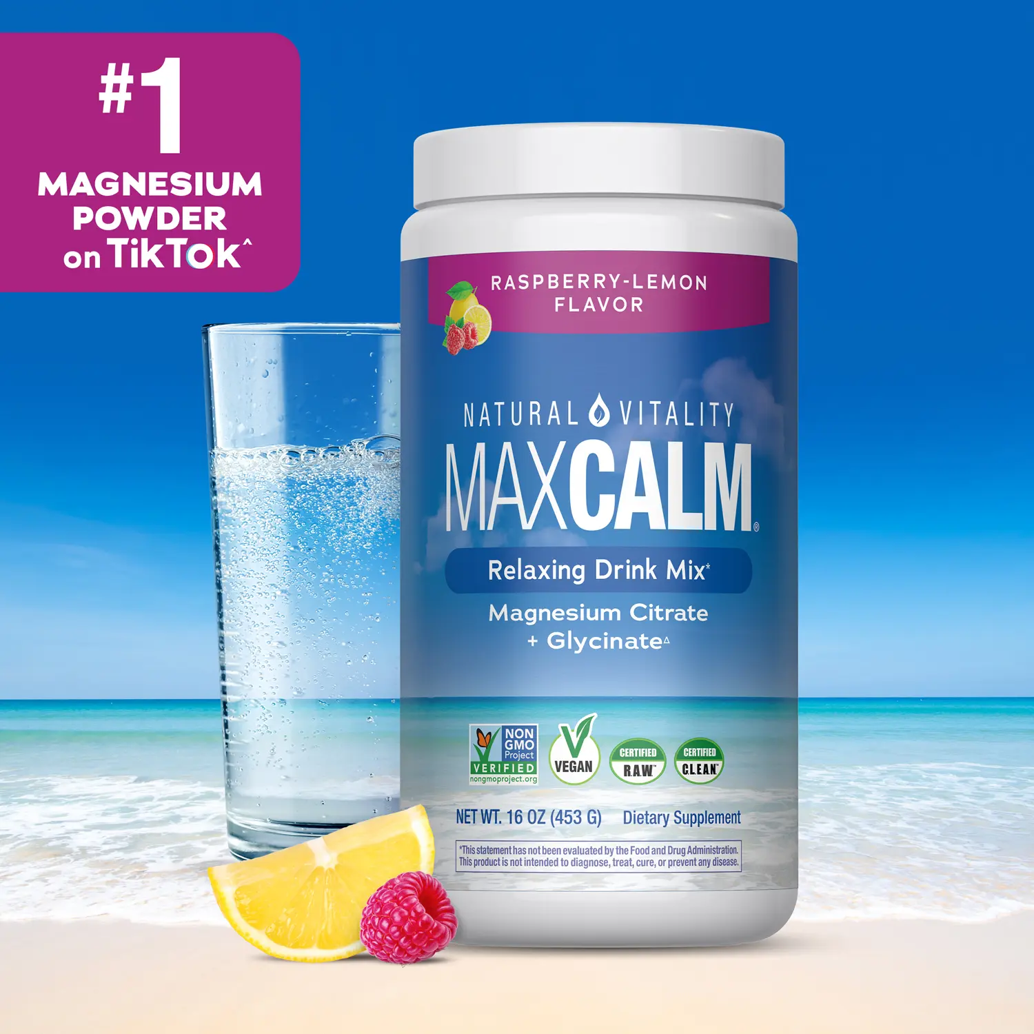 MAXCALM® Raspberry-Lemon magnesium powder canister with a fizzing pink drink on soft sand