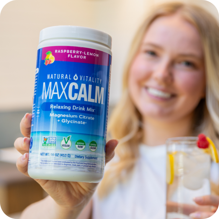 A MAXCALM® fan holding the Raspberry-Lemon canister and a fresh raspberry-lemon drink